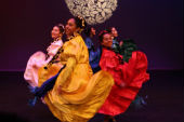 UCSC mainstage students in colorful dresses dancing the region of Michoacan